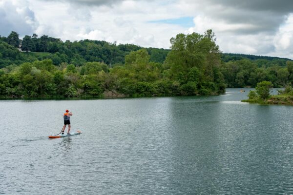 man on paddle board on lake
